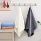 White, beige, and blue towels hanging on a wall with a cabinet below.