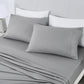Gray striped bedding set on a bed with white pillows.