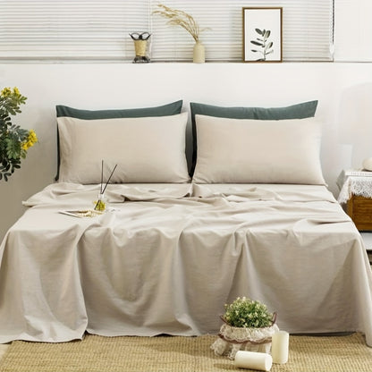 Neatly made bed with beige bedding and green pillows in a bedroom setting.