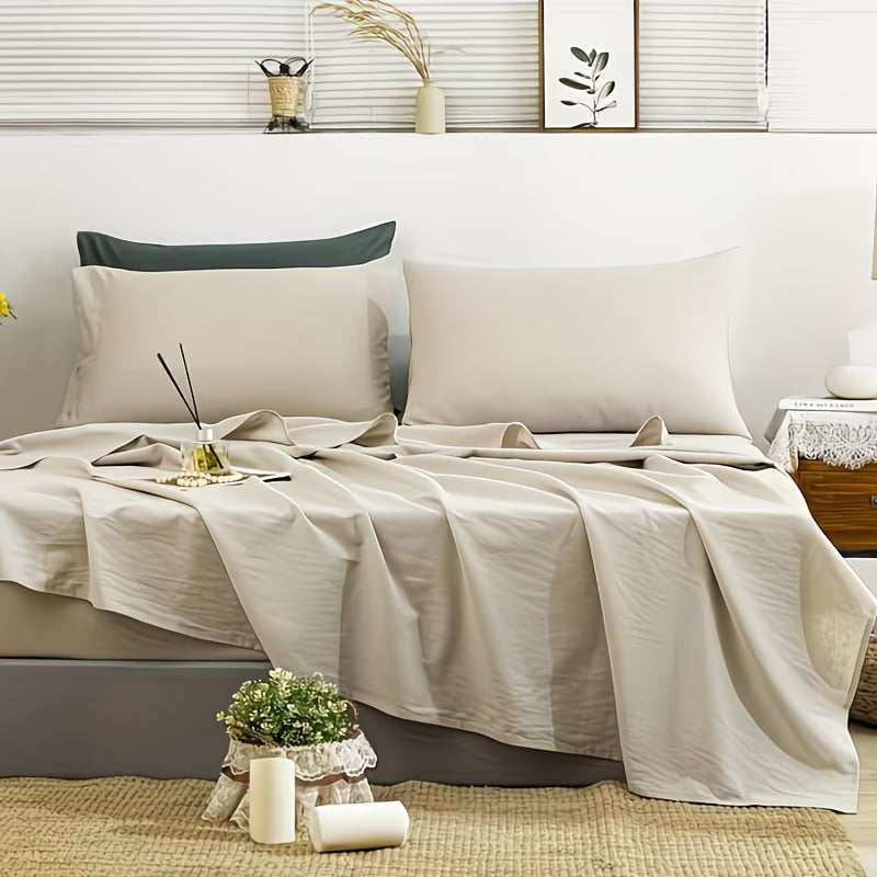 Neatly made bed with beige bedding in a bedroom setting.