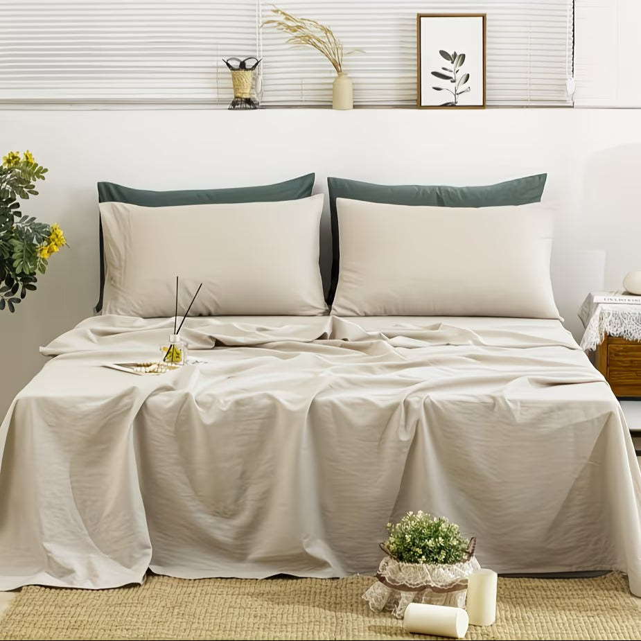 Neatly made bed with beige bedding and green pillows in a bedroom setting.