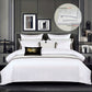 White bedding set on a bed with decorative pillows in a bedroom setting.