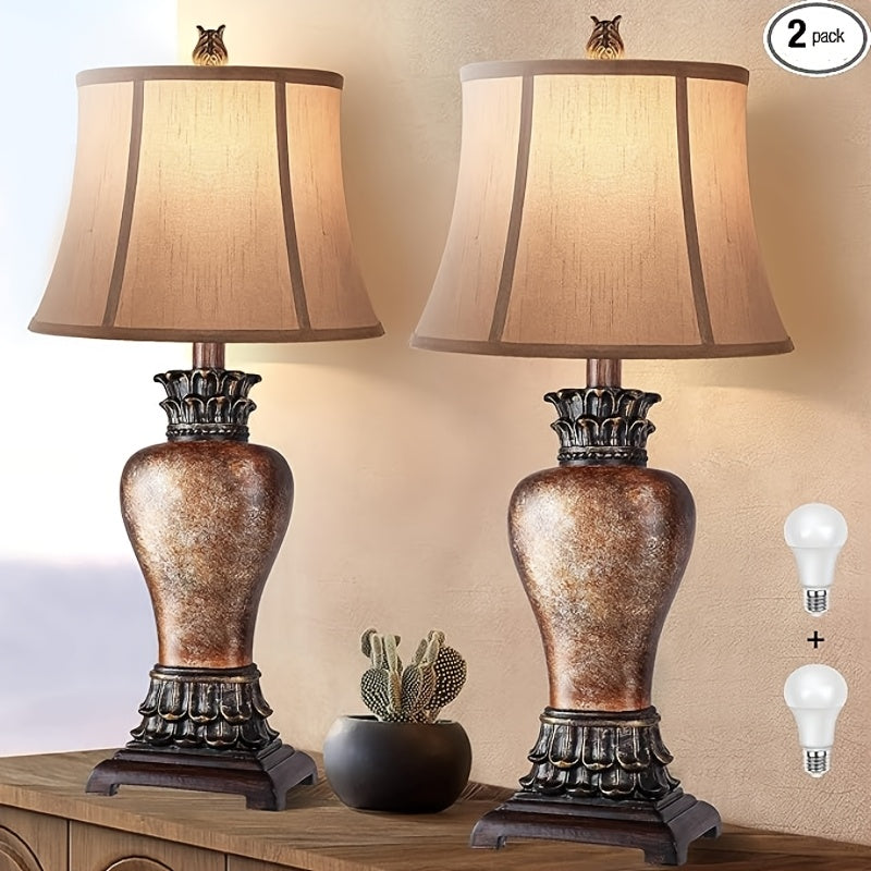 Two decorative table lamps with brown and beige shades on a wooden surface, with two light bulbs displayed.