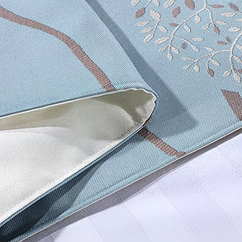 Close-up of a light blue fabric with floral patterns on a white surface
