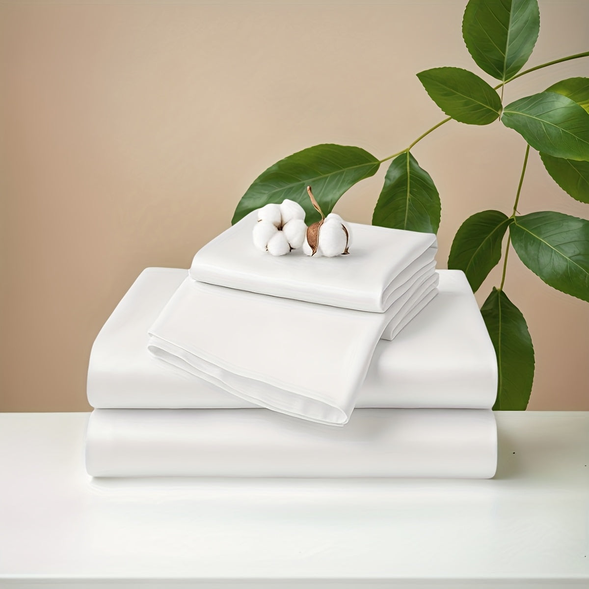 Stack of white folded sheets on a light surface with green leaves in the background