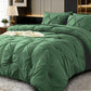 Green textured comforter set on a bed in a bedroom setting.