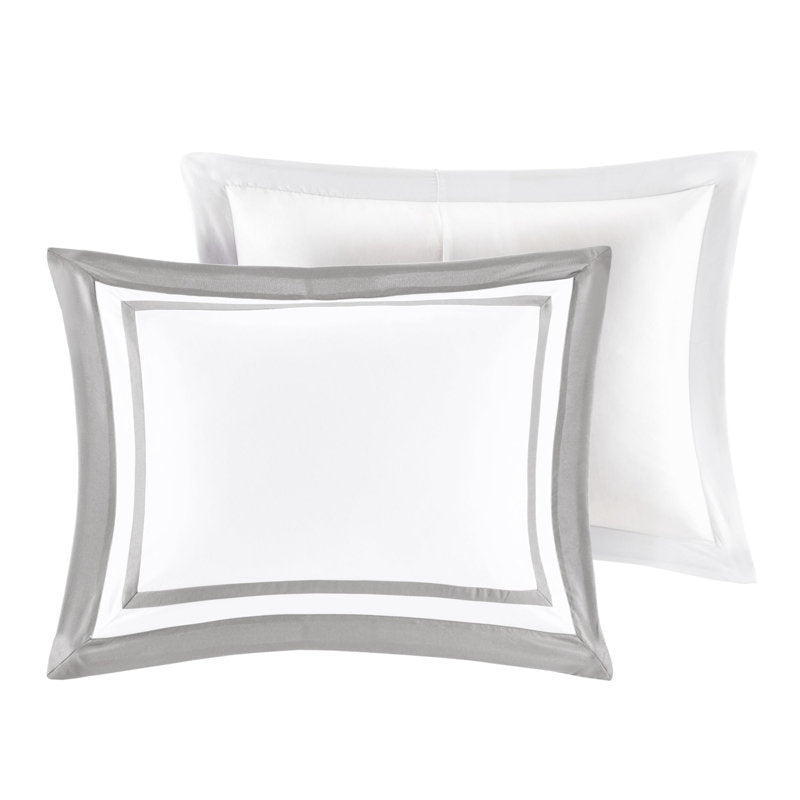 Two white pillows with gray decorative borders on a white background