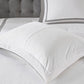 White comforter on a bed with gray headboard