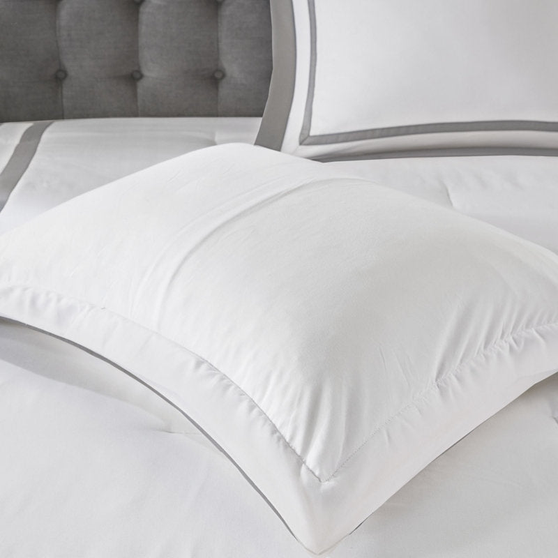 White comforter on a bed with gray headboard