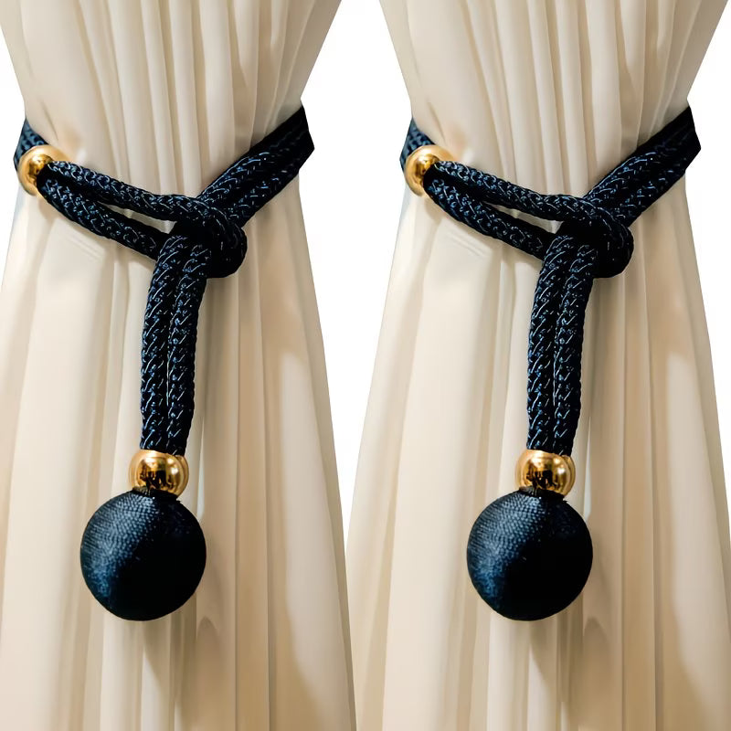 Curtain tiebacks with black balls and gold accents on beige curtains
