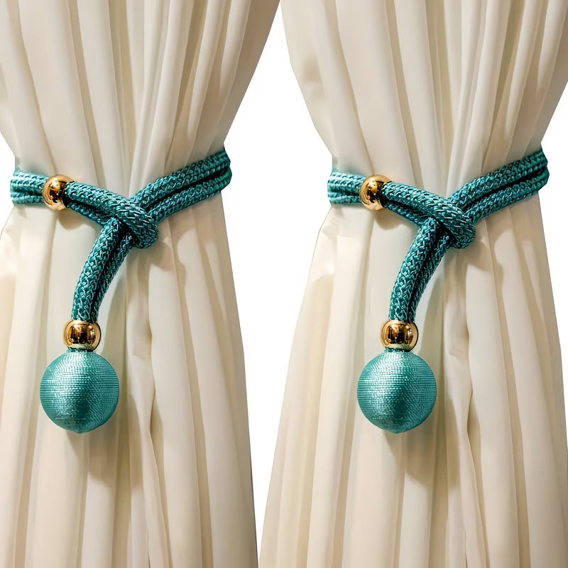Teal curtain tiebacks with gold accents on white curtains