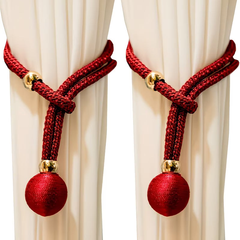 Red curtain tiebacks with gold accents on white curtains