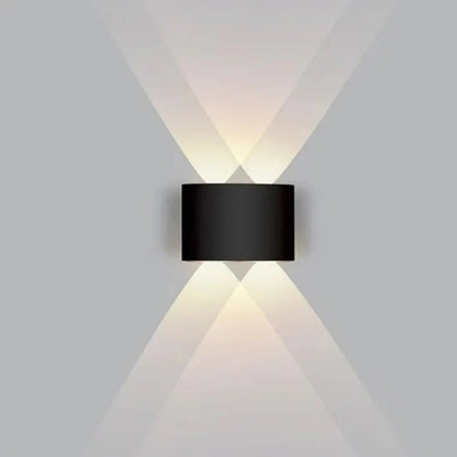 Black wall-mounted light fixture casting light on a gray wall