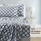 Bed with black and white patterned bedding, nightstand, and lamp in a bedroom setting.