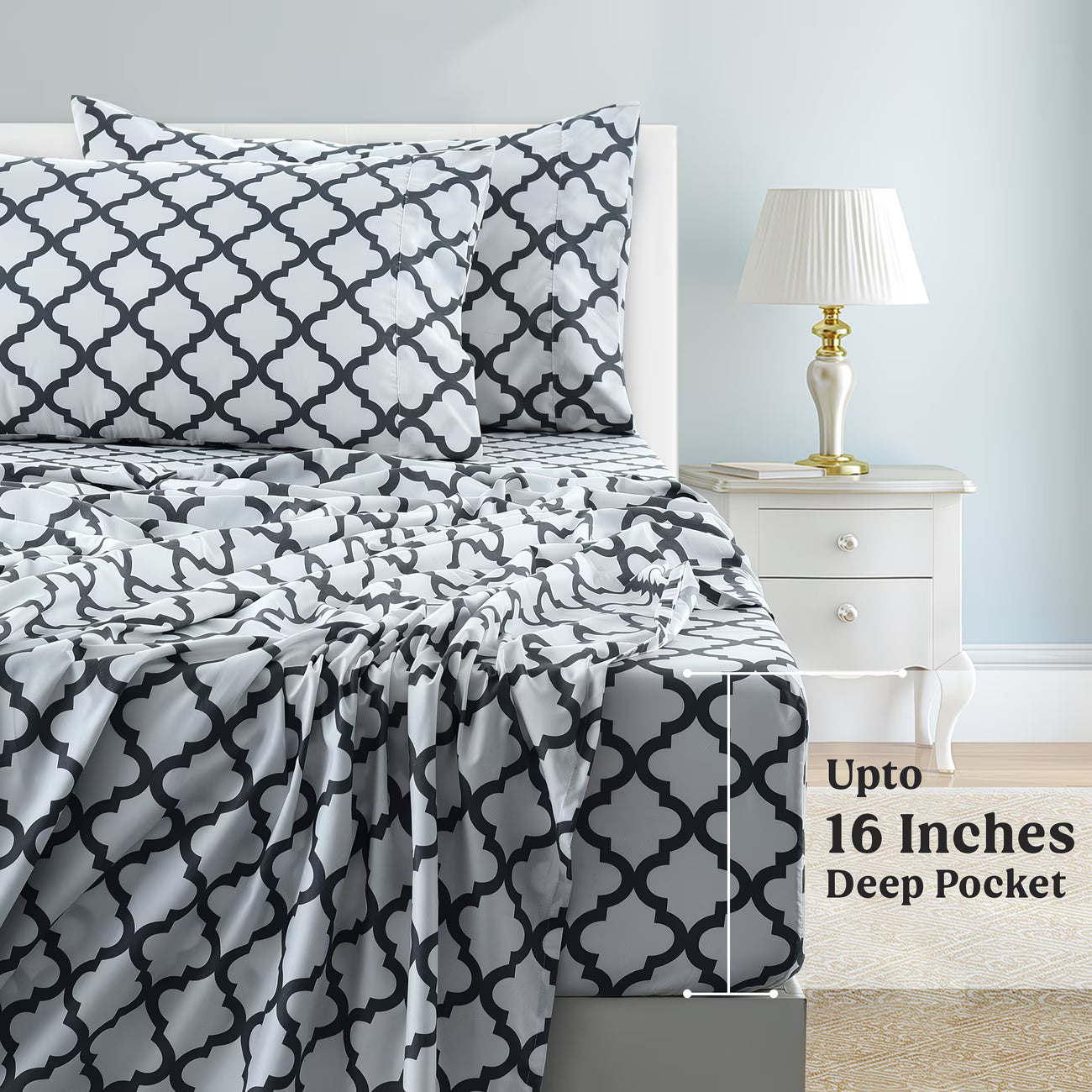 Bed with black and white patterned bedding, nightstand, and lamp in a bedroom setting.