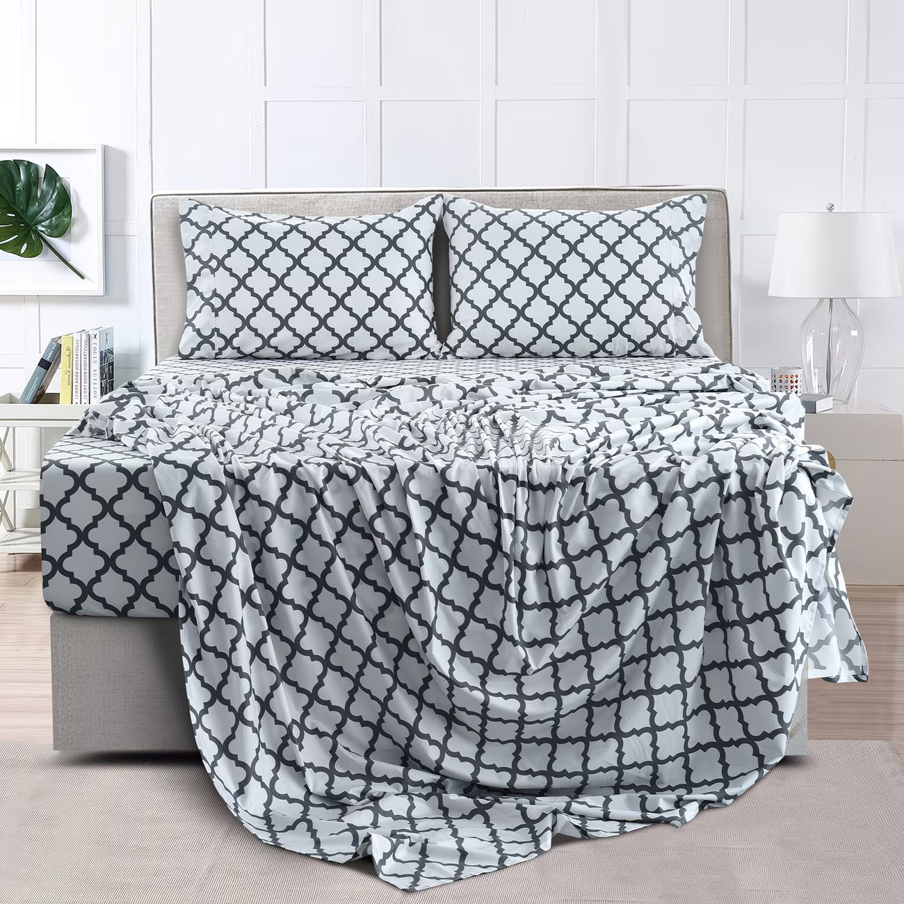 Bed with geometric patterned bedding and pillows in a bedroom setting.