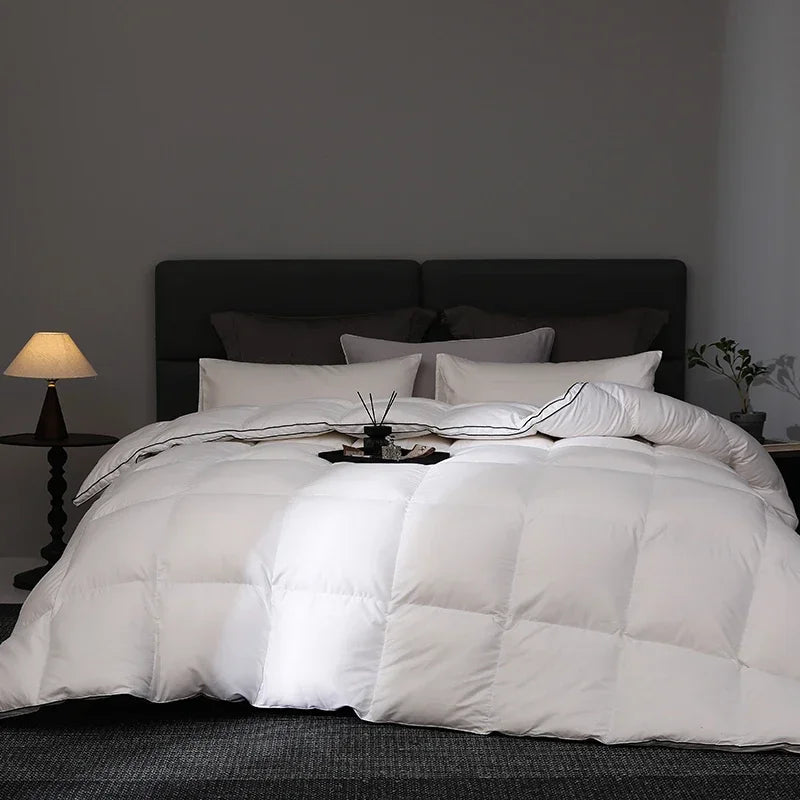 White comforter on a bed in a darkly decorated room