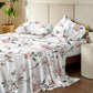 Floral patterned bedding set on a bed in a bedroom setting.