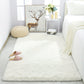 White fluffy rug in a room with a deer painting, candles, and a white chair.