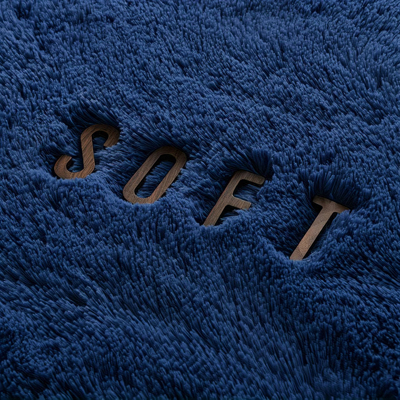 Close-up of a blue textured fabric with the word 'SOFT' embroidered on it.
