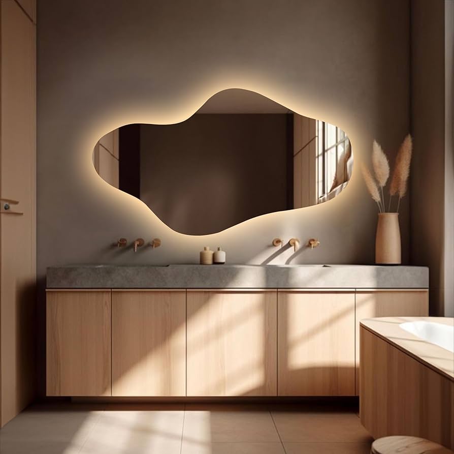Modern bathroom with a large, uniquely shaped mirror and wooden vanity.