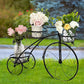 Decorative bicycle planter with flowers on a grassy background