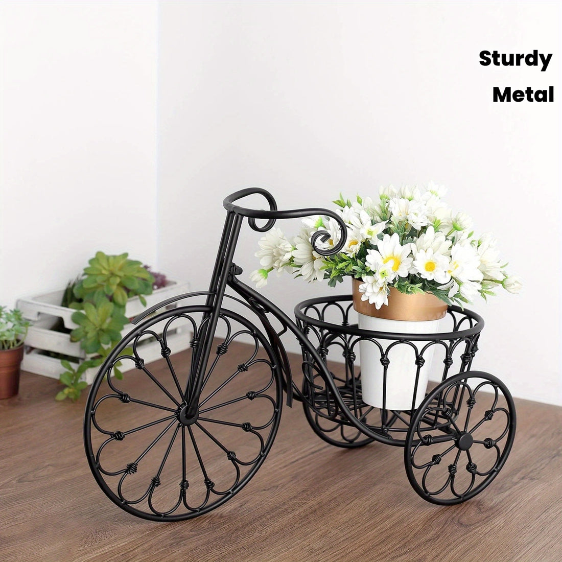 Decorative metal bicycle planter with flowers on a wooden floor