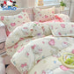 Hello Kitty themed bedding set on a bed with a window and plant in the background.