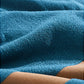 Close-up of a blue textured fabric with brown leather edges