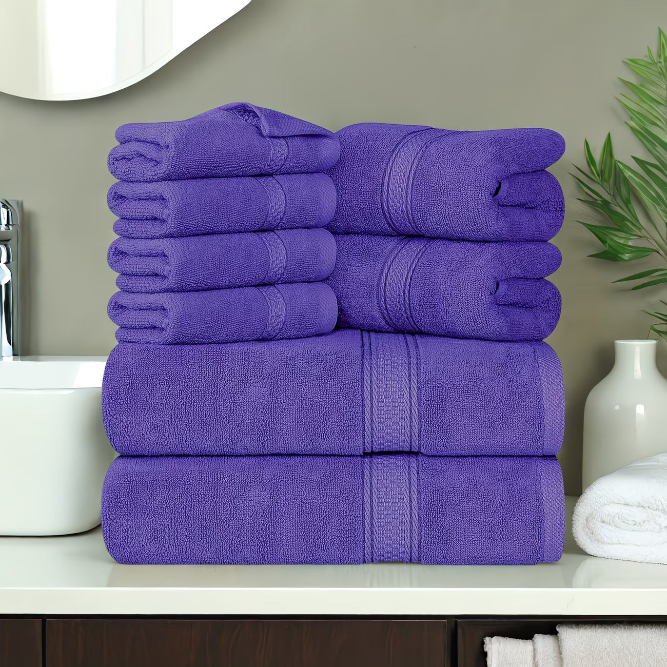 Stack of purple towels on a bathroom counter with a neutral background