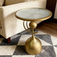 Gold side table with a round mirror top in a living room setting