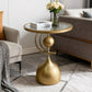 Gold side table with a glass top in a living room setting