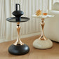 Two stylish side tables with gold and black bases on a wooden floor.