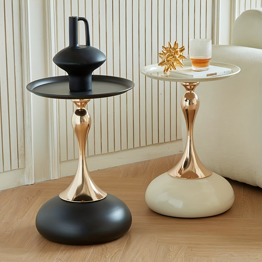Two stylish side tables with gold and black bases on a wooden floor.