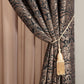 Decorative curtain with intricate pattern and tassel tieback against a neutral background