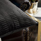 Black textured pillow on a brown leather chair with a blurred background