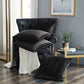 Dark leather armchair with textured cushions in a living room setting.