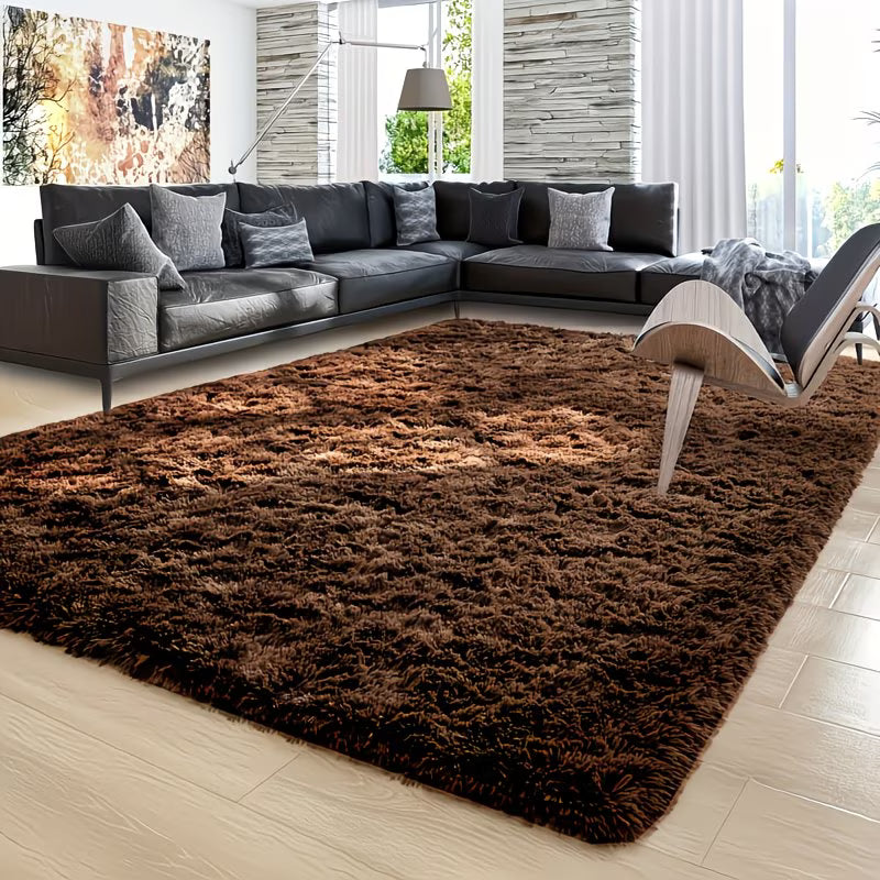 Brown shaggy rug in a living room with a sectional sofa and modern chair.