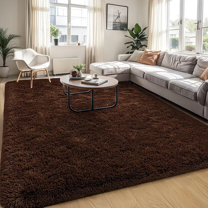Living room with a brown rug, gray sectional sofa, and white chair.