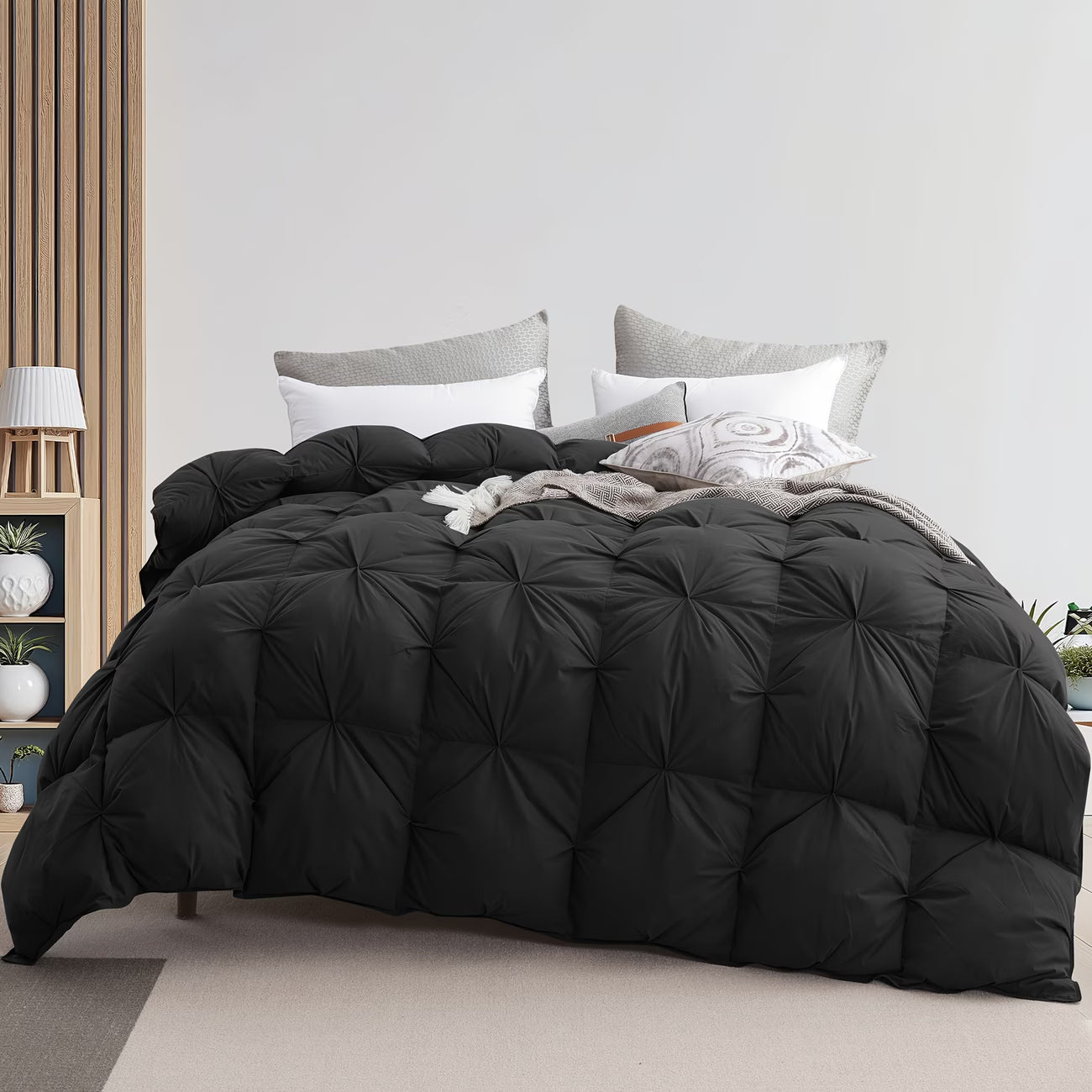 Black quilted comforter on a bed with pillows in a bedroom setting