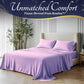 Purple bedding set on a bed with 'Unmatched Comfort' text and bamboo plant in the background