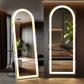 Two illuminated floor mirrors in a modern bedroom setting.