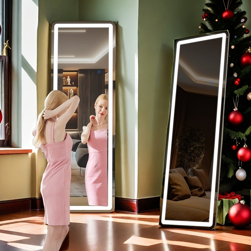 Woman in a pink dress standing in front of two full-length mirrors in a room with a Christmas tree.