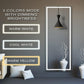 Smart mirror with LED light strip displaying color modes on a wall.