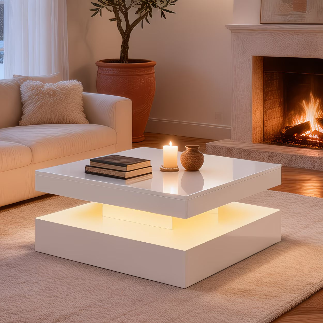 Modern living room with a white coffee table, books, and a candle in front of a fireplace.