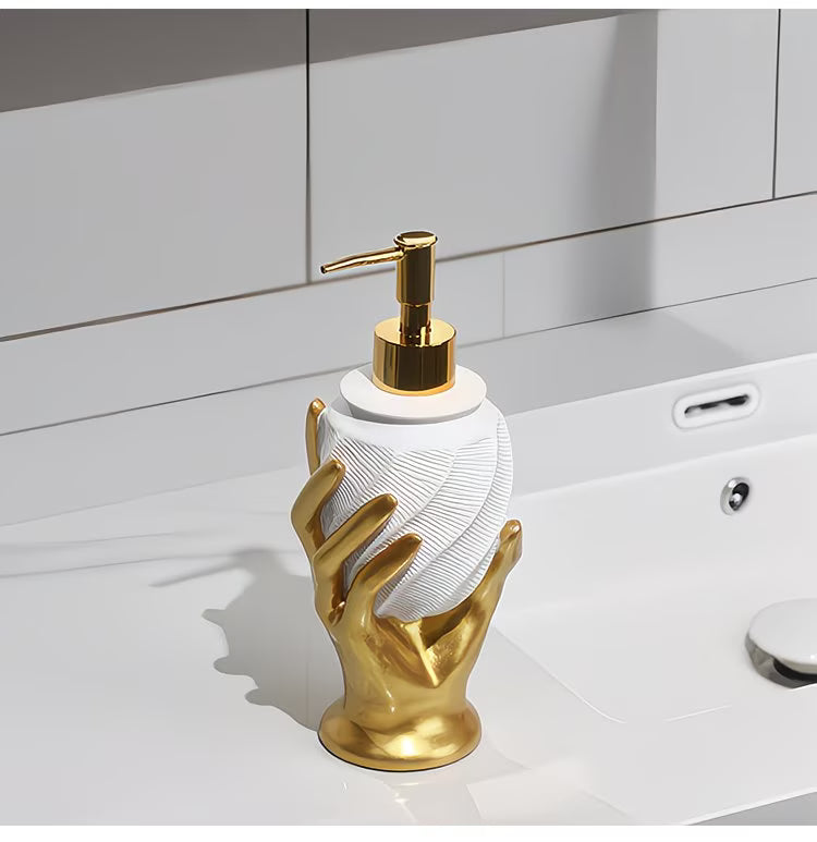 Decorative soap dispenser with gold base and white pump on a bathroom counter.