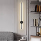 Modern wall-mounted light fixture in a living room setting with shelves and a sofa.