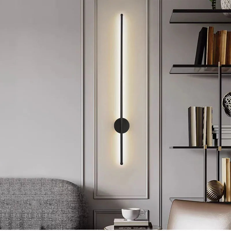 Modern wall-mounted light fixture in a living room setting with shelves and a sofa.