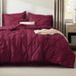 Maroon bedspread with matching pillows on a bed in a bedroom setting.
