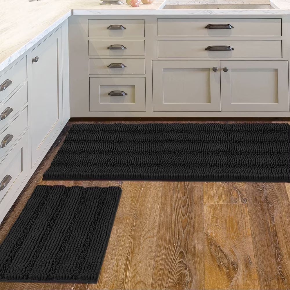 Black kitchen mats on a wooden floor with white cabinets in the background